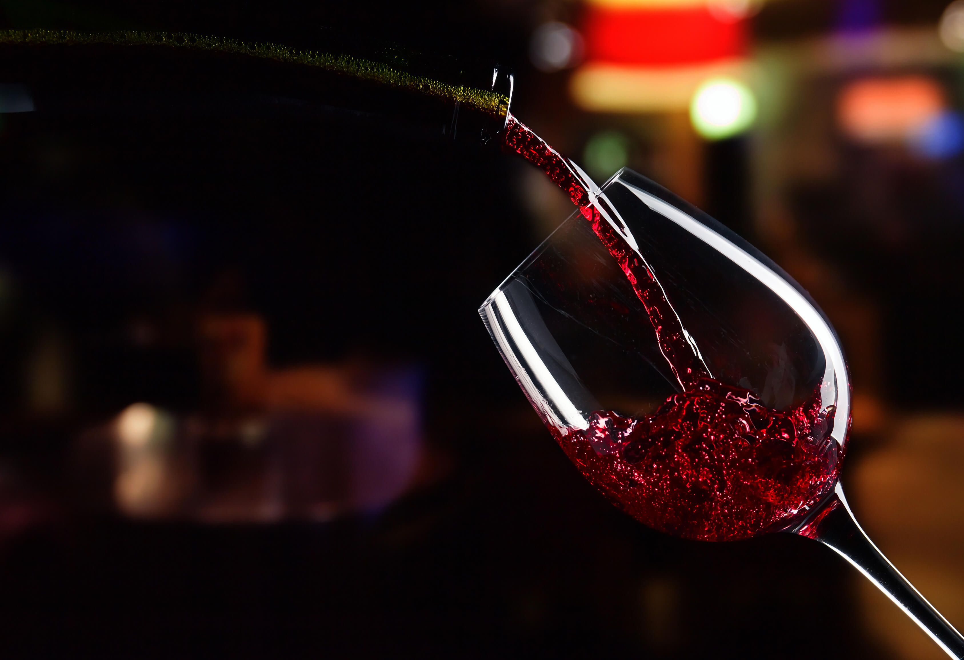 bottle and glass with red wine on  dark background